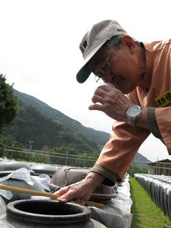 黒酢の仕上がりを確認する杜氏、赤池力